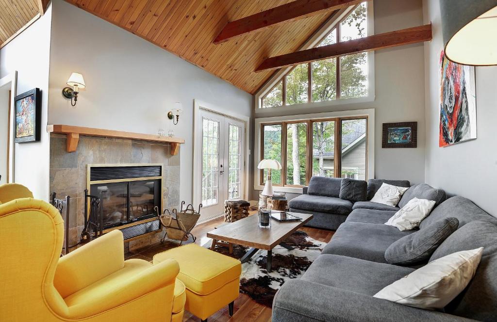 a living room with a couch and a fireplace at Chalets Alpins - 56 Chemin des Skieurs in Stoneham