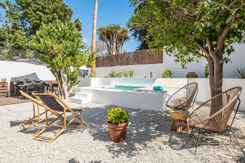 un patio trasero con 2 sillas y una piscina en La Huertita de Arona Tenerifesummervillas, en Arona