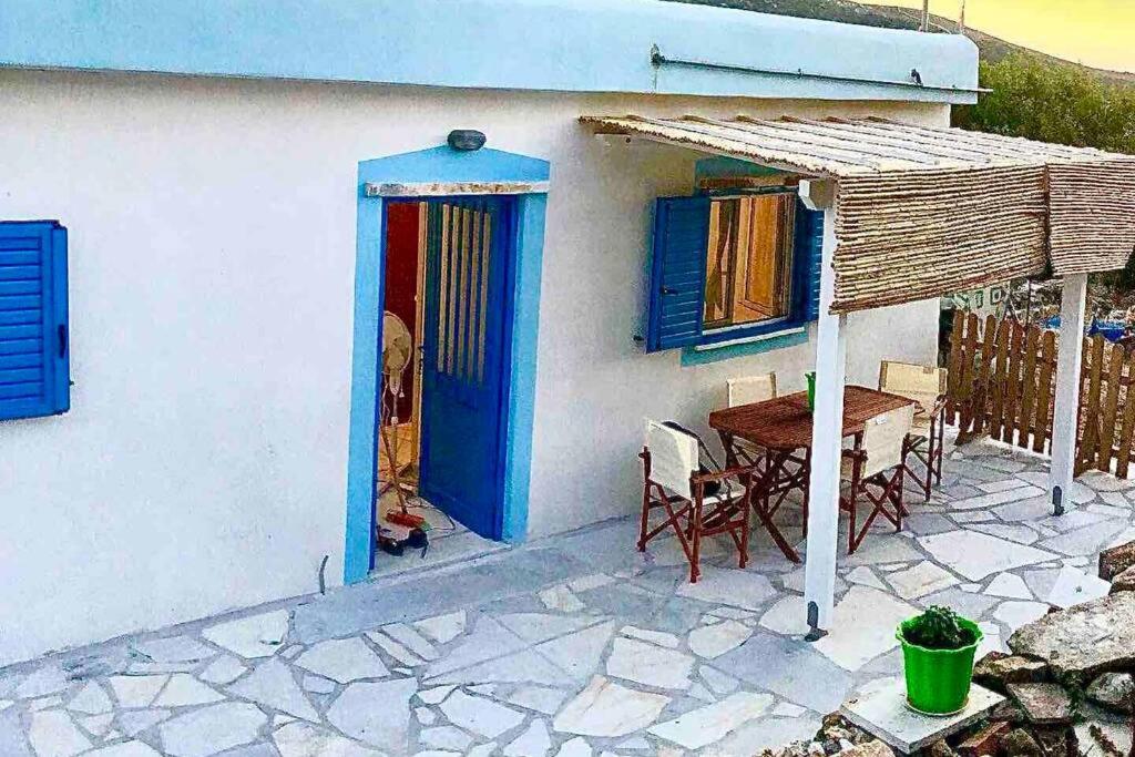 a house with a blue door and a table and chairs at Old vineyard in Kinídharos