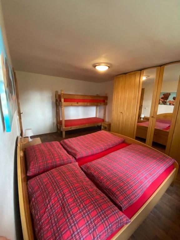 a bedroom with a large bed with red sheets at Chalupa u Josefa in Josefuv dul