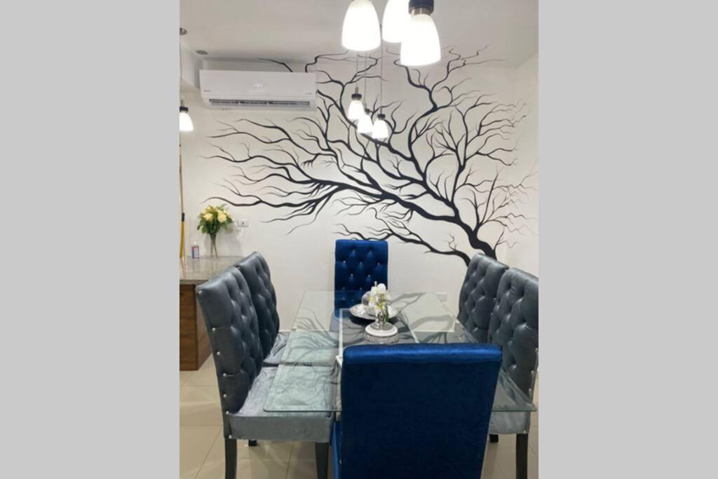 a dining room with a tree mural on the wall at Paramount 3-Bedroom Apartment with Parking in San Felipe de Puerto Plata