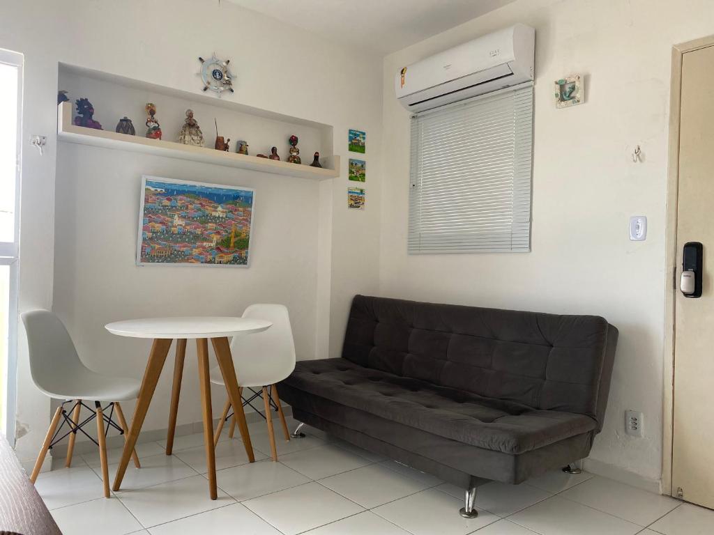 uma sala de estar com um sofá e uma mesa em Encantos do Porto da Barra em Salvador