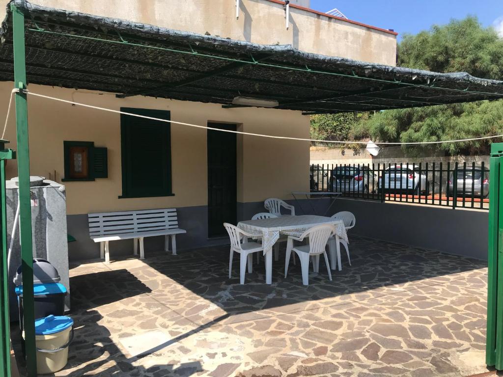d'une terrasse avec une table, des chaises et un banc. dans l'établissement Alba Holiday House , Casa Vacanze Ricadi, à Santa Maria
