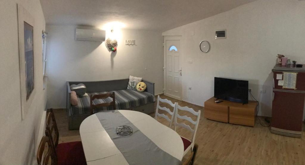 Televízia a/alebo spoločenská miestnosť v ubytovaní Apartman Arijana s pogledom na more za 6 osoba