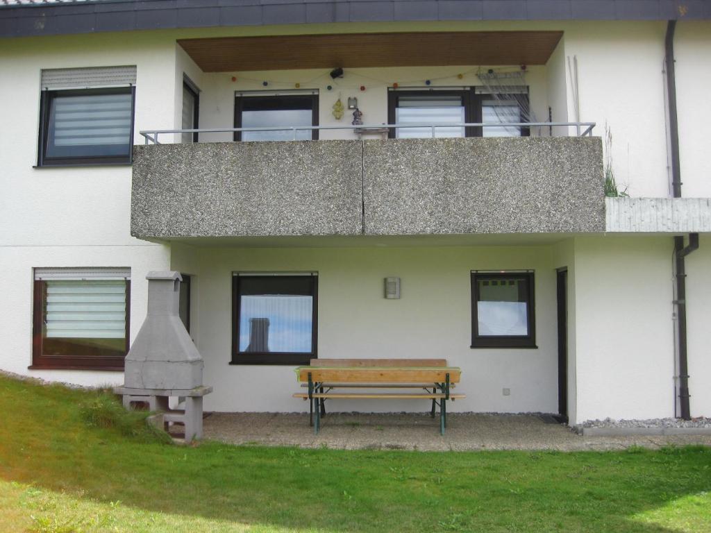 un banco frente a una casa con balcón en Haus Weißbrod, en Essingen