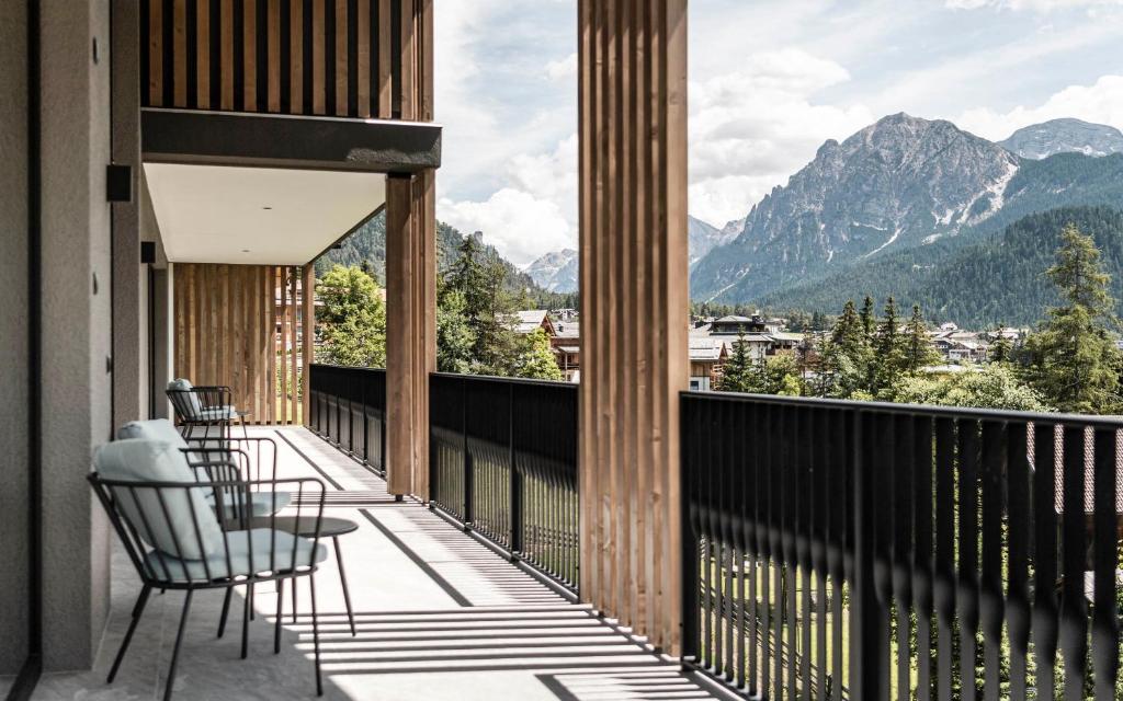 a balcony with chairs and a view of mountains at Residence Le Fostü in San Vigilio Di Marebbe