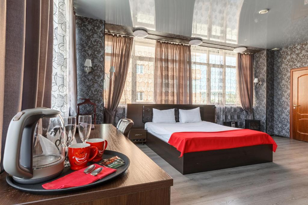 a hotel room with a bed and a table with a mixer at City Hotel in Moscow