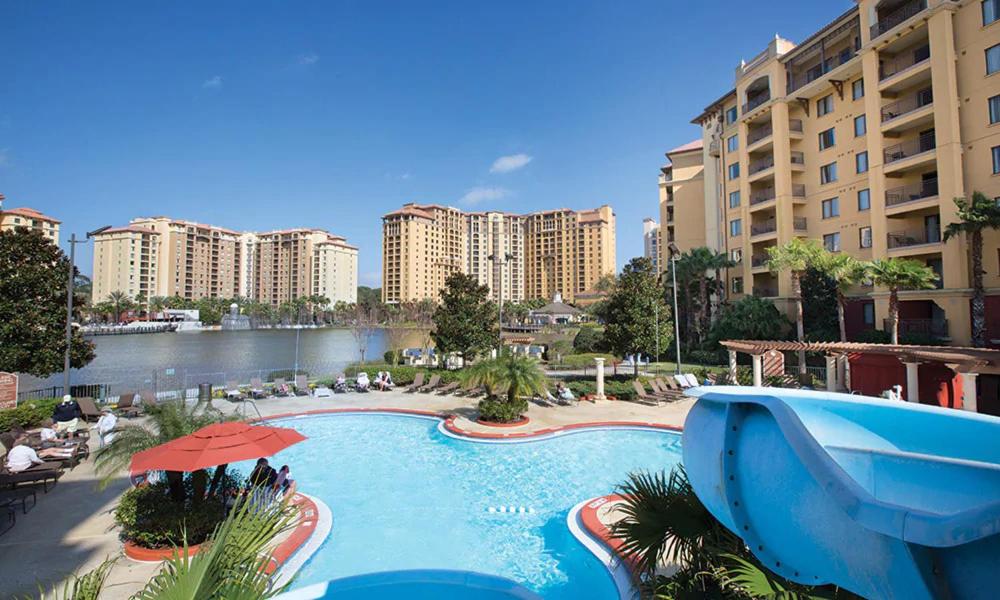 a large swimming pool in a resort with buildings at Club Wyndham Bonnet Creek Resort with Disney shuttles and near Universal Studios in Orlando