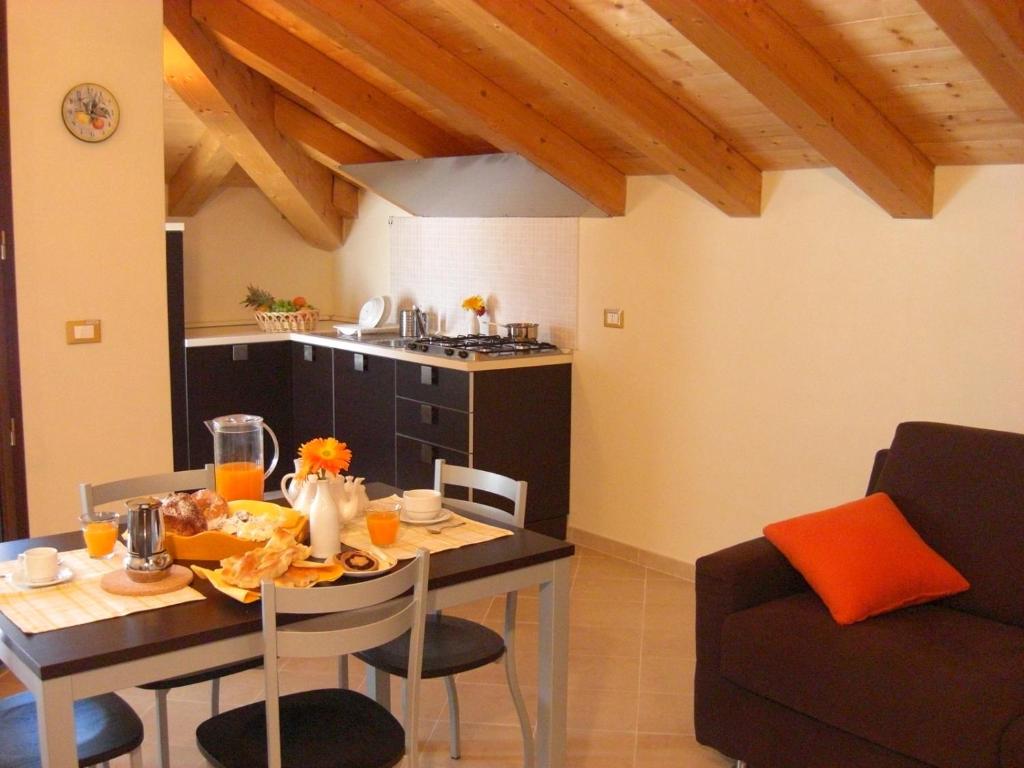 a kitchen with a dining table and a table and chairs at LES BIJOUX Apartments in Pietra Ligure
