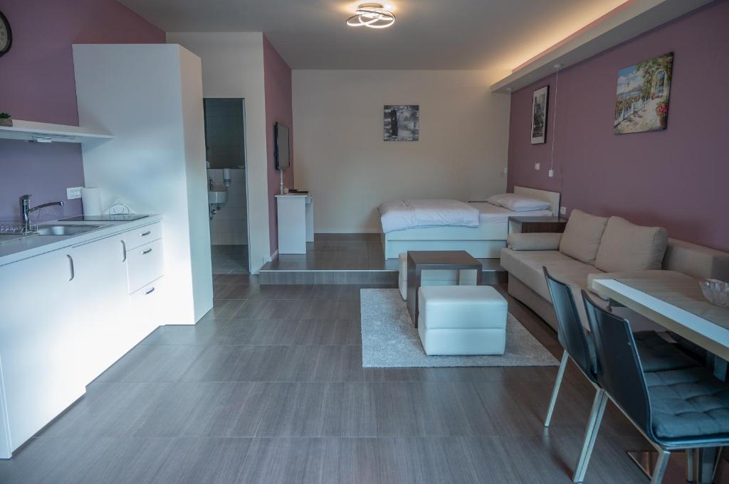 a kitchen and living room with a couch and a bed at Hana - Apartments in Ljubljana