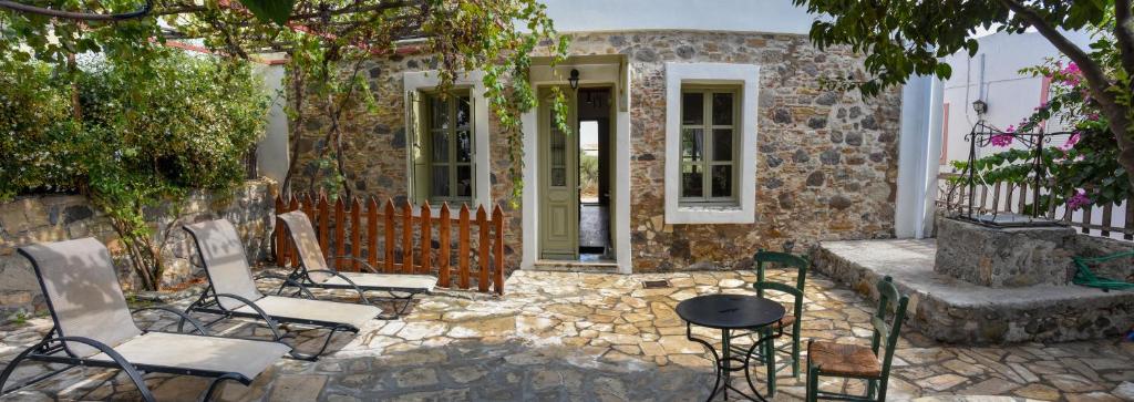 a patio with chairs and a table and a house at Stone House Kleio Kos in Antimácheia