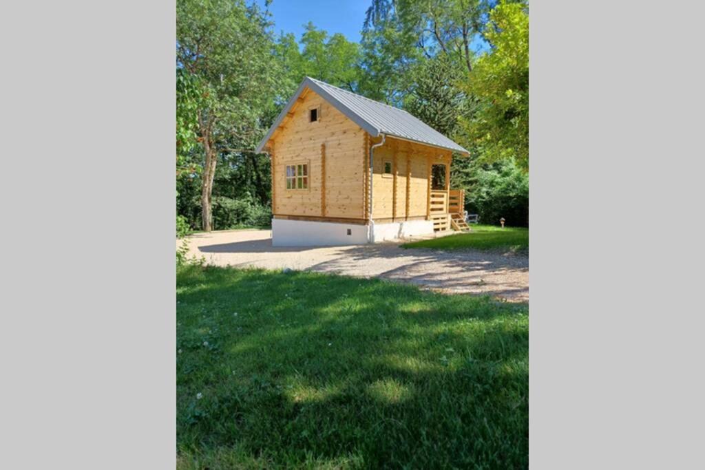 un edificio de madera con garaje en un patio en L'orée des bois , détente et calme . en Mésigny