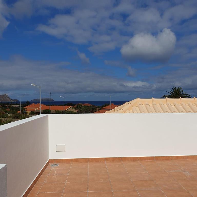 a white wall with a tile floor next to a building at Casa Azul in Porto Santo
