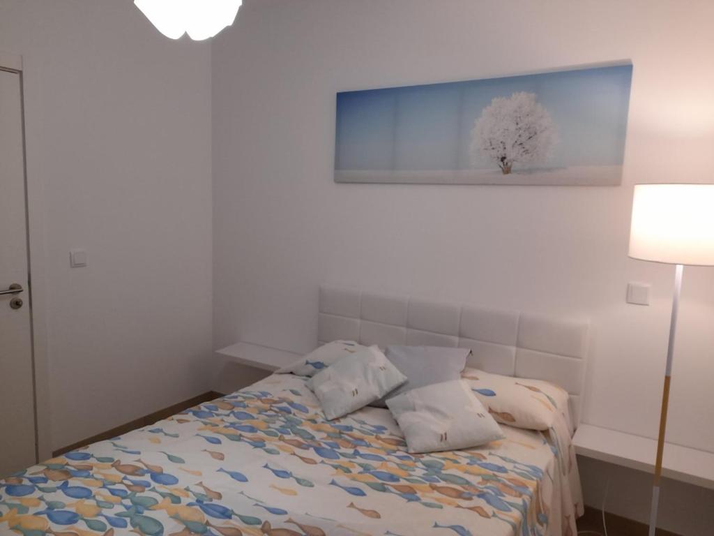 um quarto com uma cama com uma pintura azul na parede em Casa Azul em Porto Santo