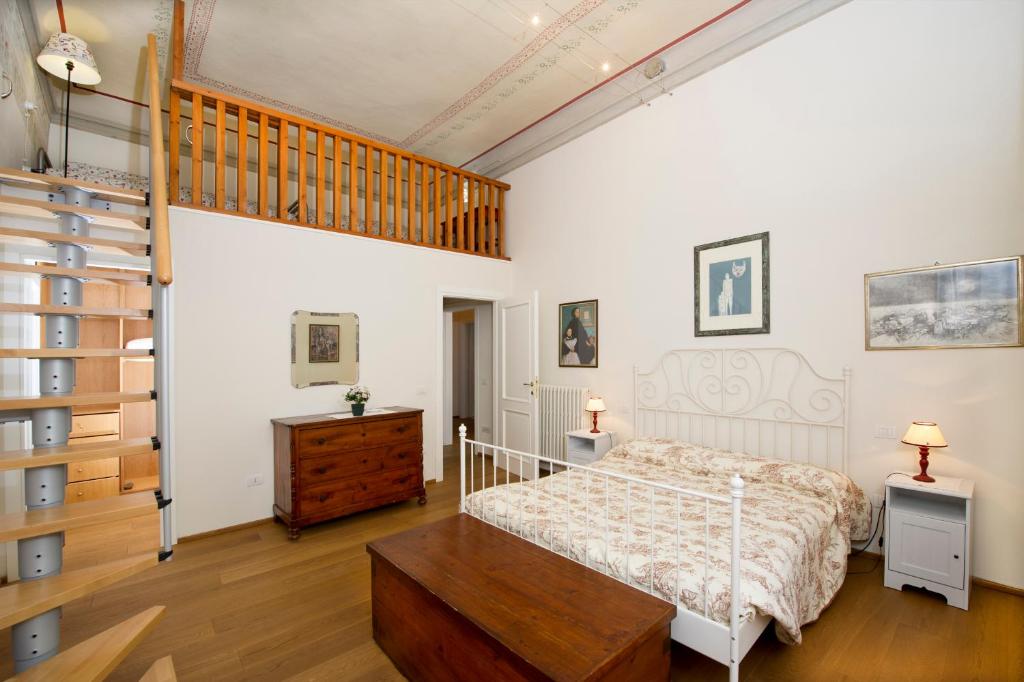 um quarto com uma cama e piso em madeira em Le Antiche Scale em Lucca