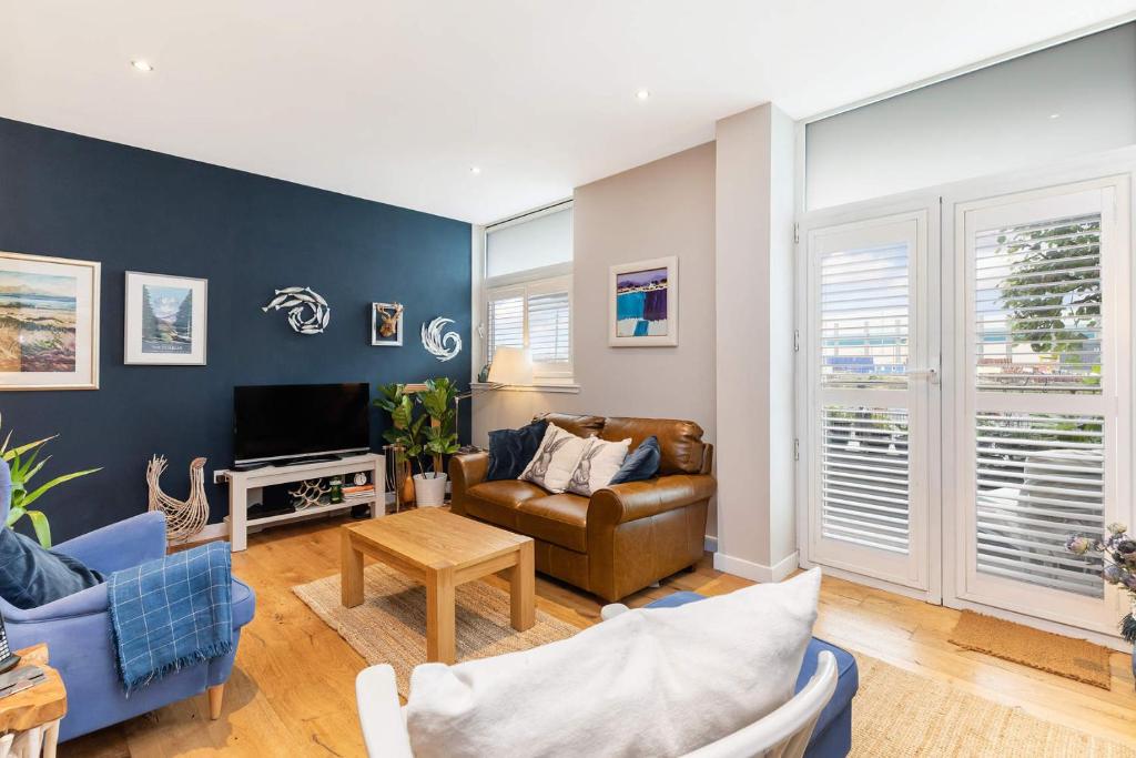 a living room with a couch and a tv at Glasgow Harbour Clyde Waterfront Apartment in Glasgow