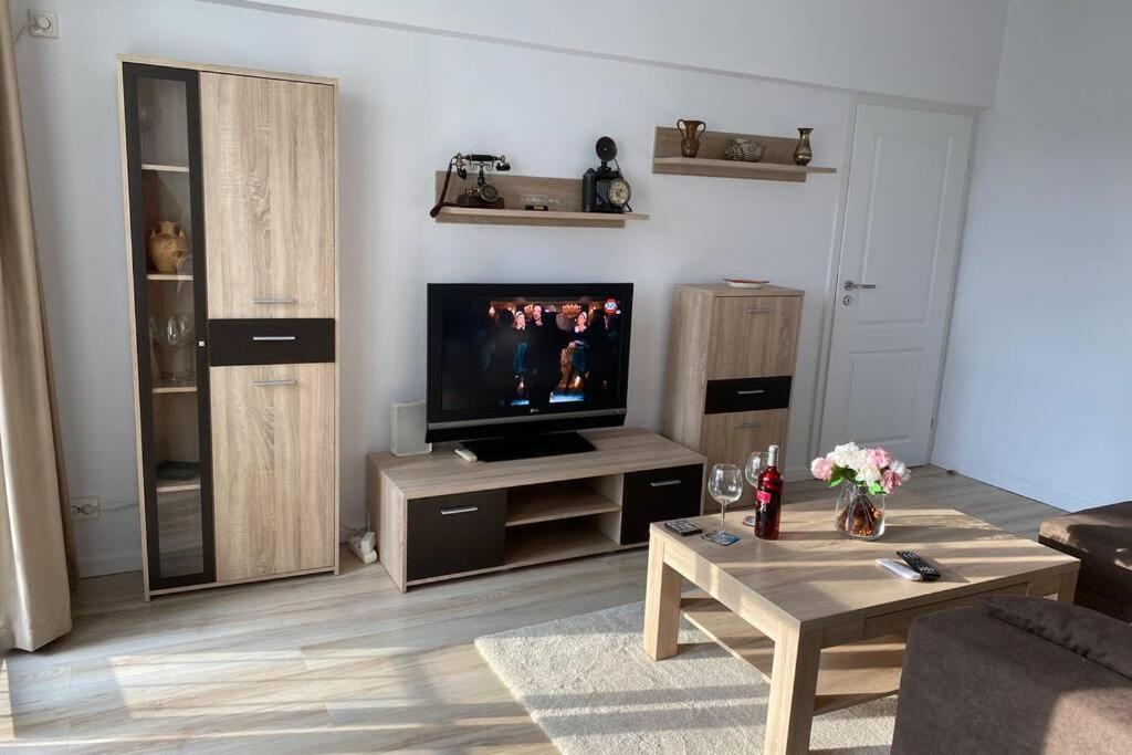 - un salon avec une télévision et une table basse dans l'établissement Magheru cozy new apartament 2 rooms, à Bucarest