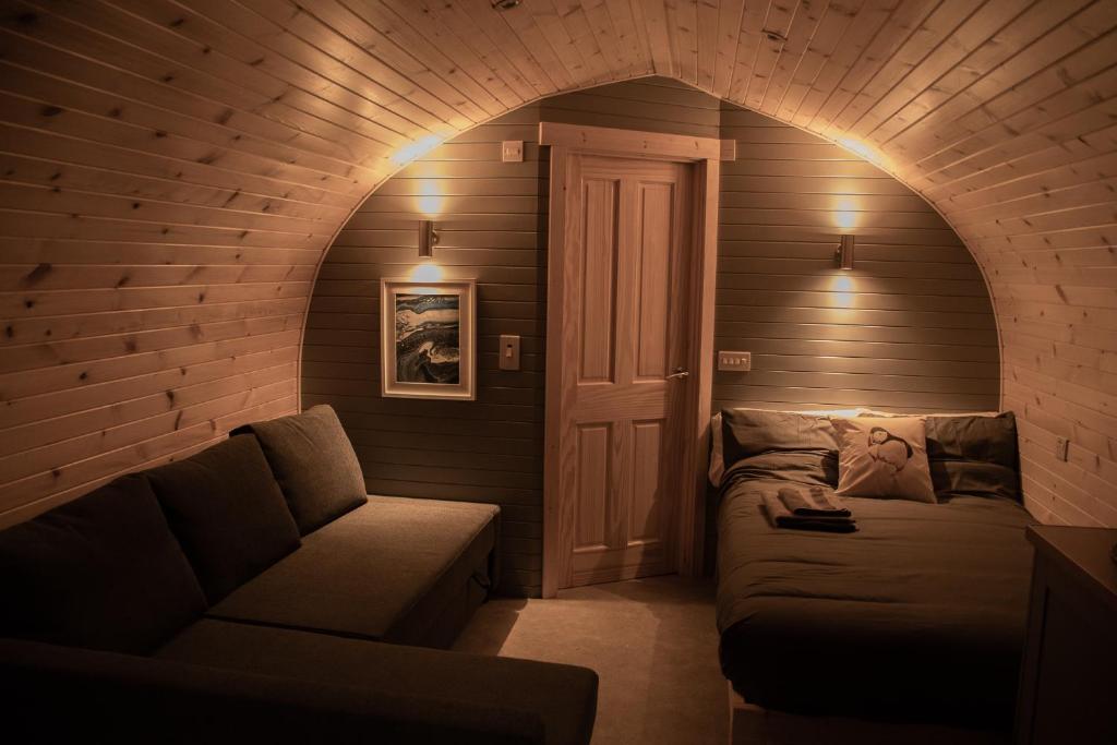 ein Wohnzimmer mit einem Sofa und einem Stuhl in der Unterkunft Wild Northumberland Glamping in Hexham