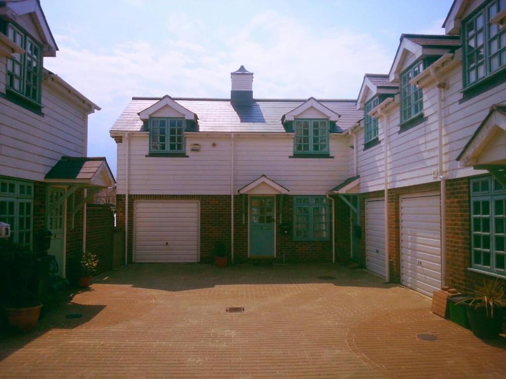 a large pink house with two garage doors at Bo's Holiday Cottage in Eastbourne