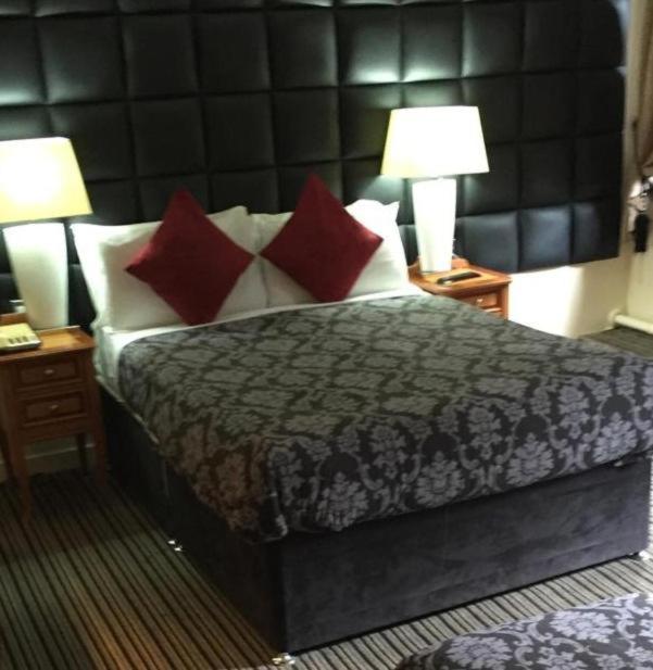 a bedroom with a bed with red and white pillows at MK Central Stay in Milton Keynes