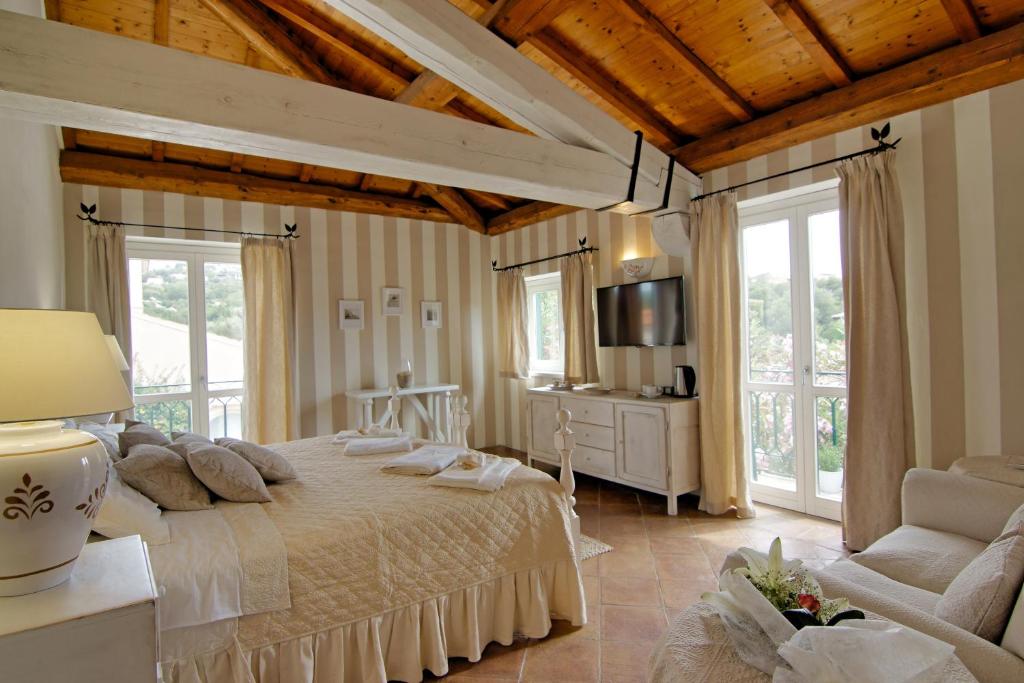 a bedroom with a bed and a couch and windows at Domus Corallia-Luxury Rooms in Porto Rotondo