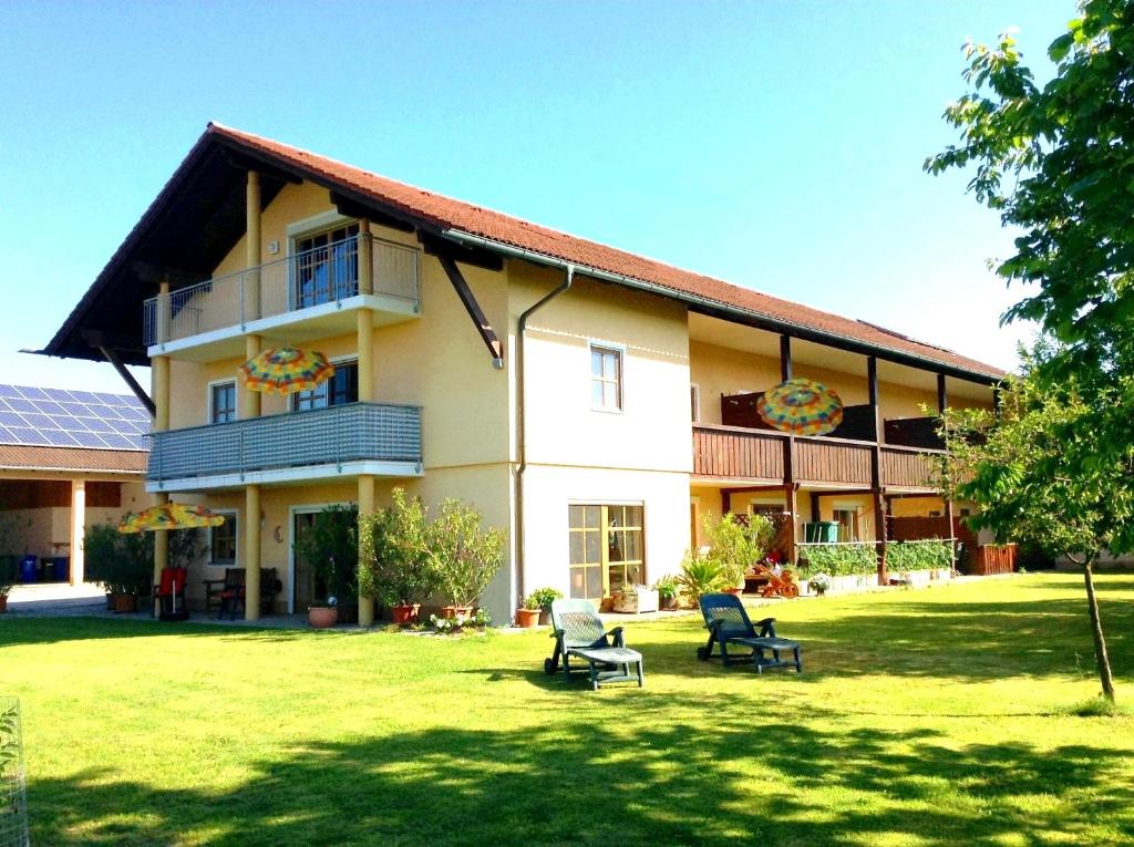 ein großes Haus mit zwei Stühlen im Hof in der Unterkunft Appartementhaus Panny in Bad Füssing