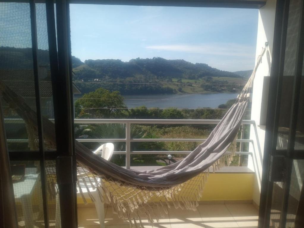 un balcón con hamaca y vistas al río en Apartamento em Marcelino Ramos ao lado das Termas, en Belém Velho