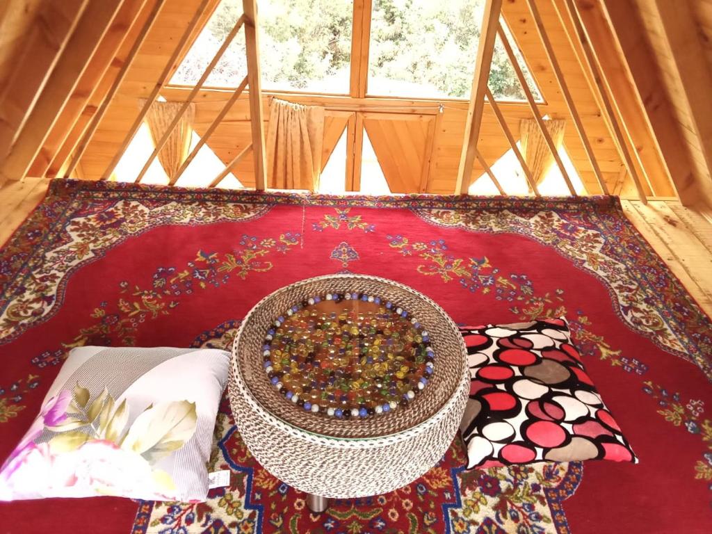 a room with a table with a bowl on a rug at Glamping las 4 estaciones in Guatavita