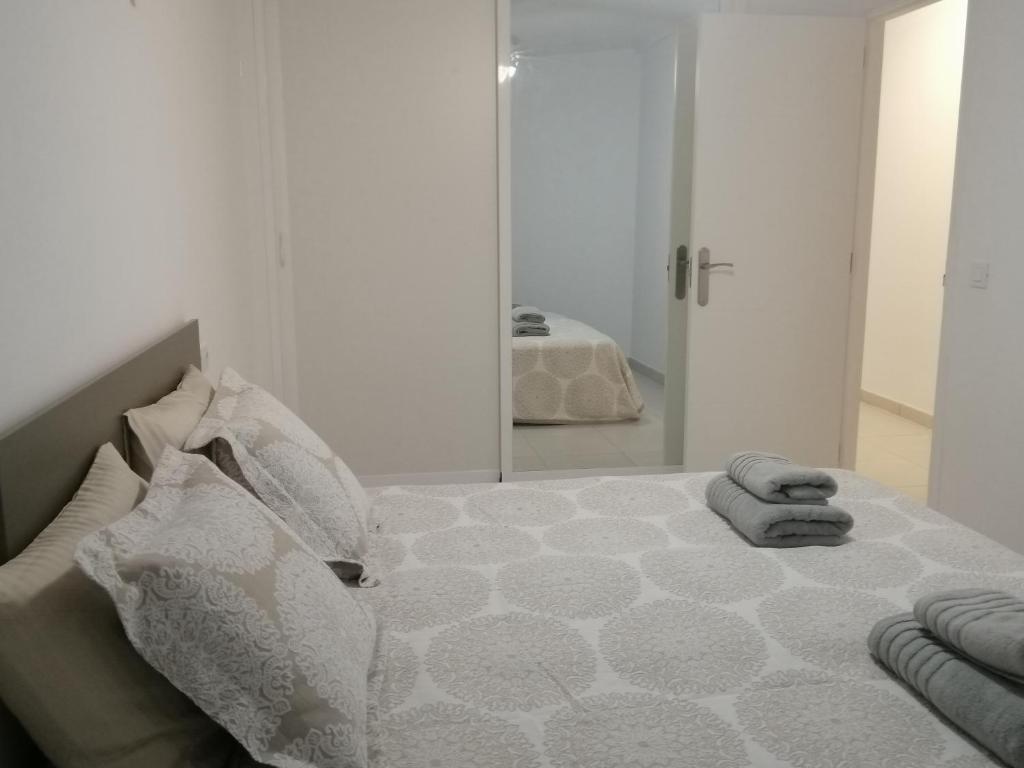 a white bedroom with a bed with a mirror at 1 bedroom playa de la Americas in Playa Fañabe