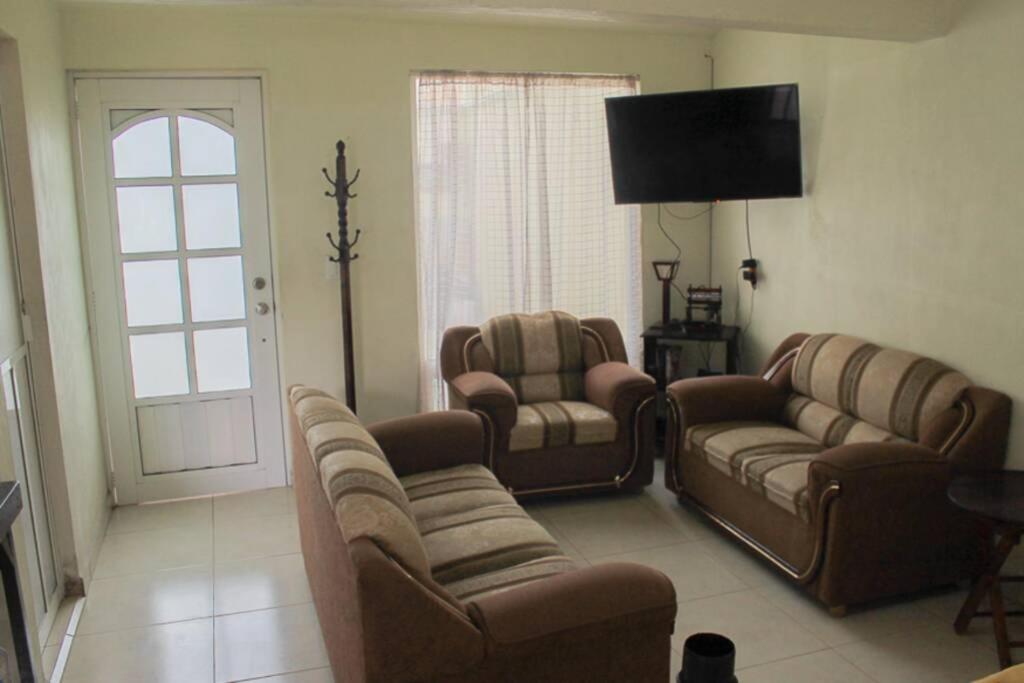 - un salon avec deux canapés et une télévision dans l'établissement Linda casa tipo loft, con estacionamiento privado., à Tulancingo