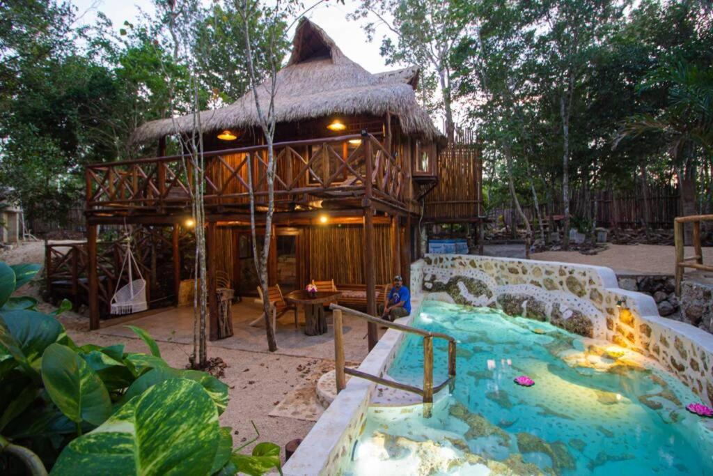 a small house with a water slide in front of it at Selvaluna cabaña eco-chic in Tulum