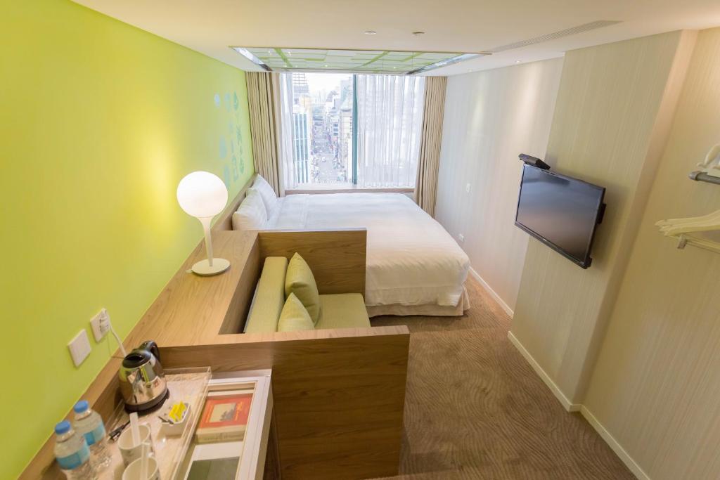 a small room with a bed and a window at Green World Hotel - Zhonghua in Taipei