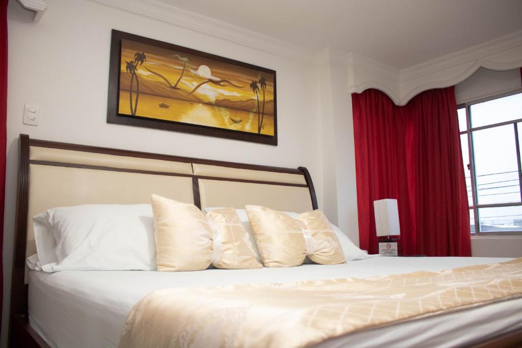 1 dormitorio con 1 cama con almohadas blancas en La Casa Blanca Hotel, en Buenaventura