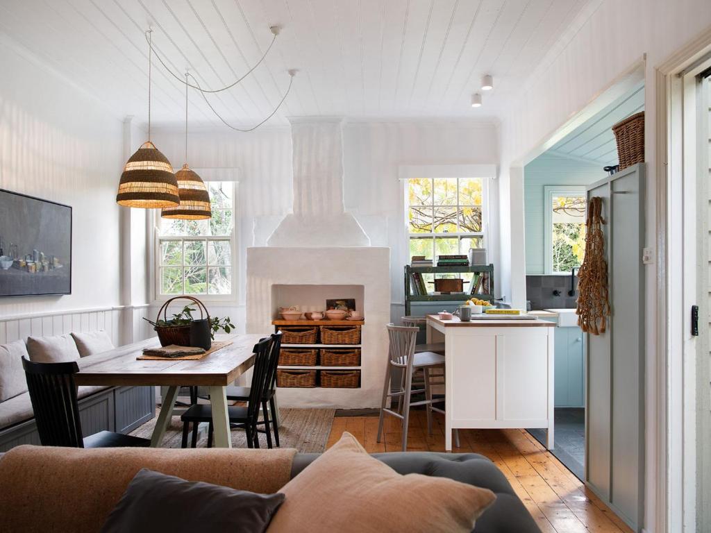 a kitchen and living room with a couch and a table at Wombat Hill Cottage in Daylesford