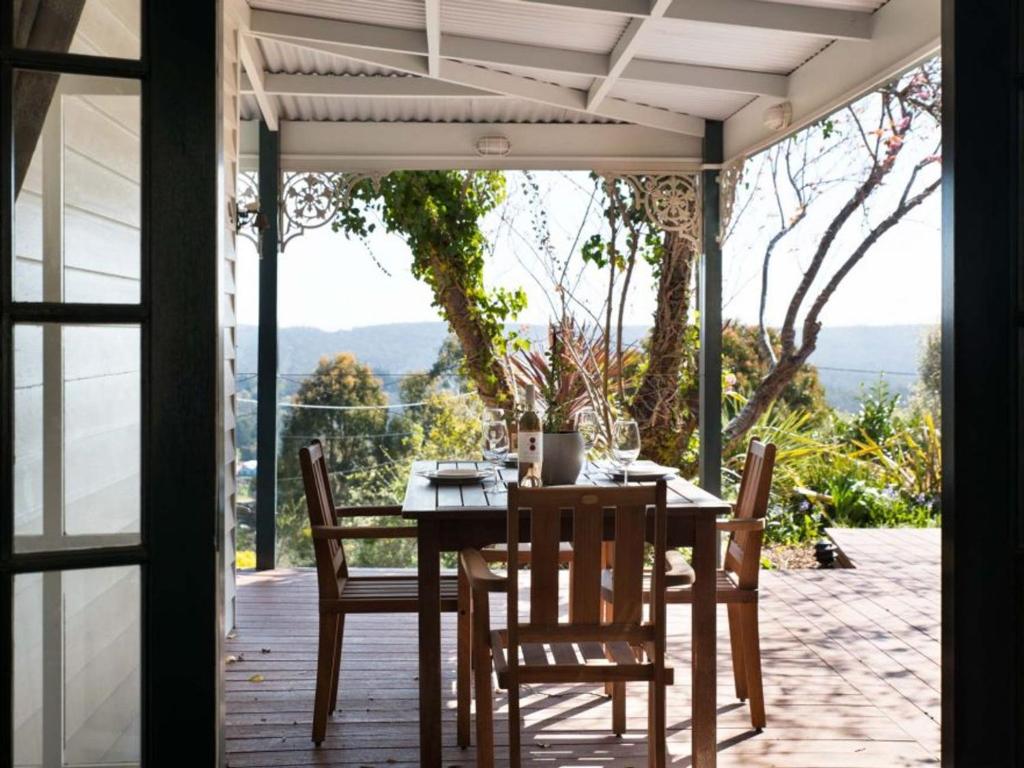 a table and chairs on a patio with a view at Gladville- old world charm with stunning views in Daylesford