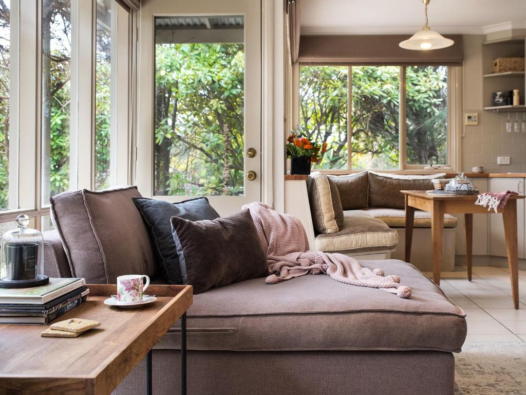 uma sala de estar com um sofá e uma mesa em The Acorn em Daylesford