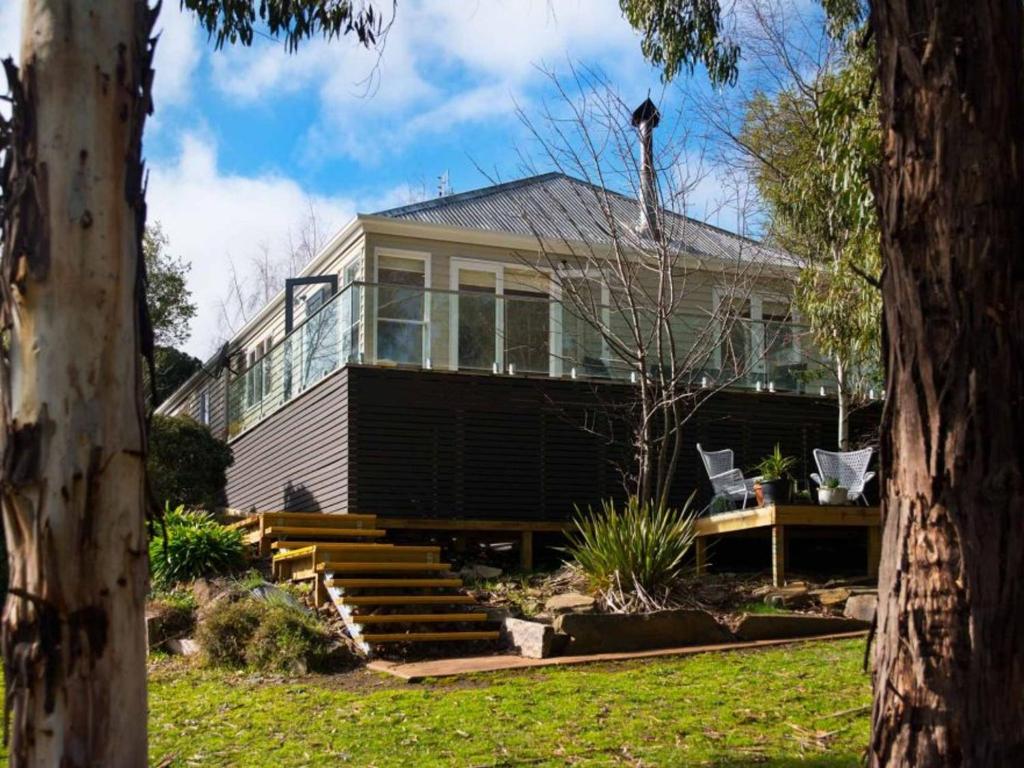 a large house with glass windows and a porch at Lake Como Villa - Lake Daylesford on your doorstep in Daylesford