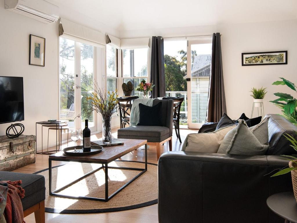 een woonkamer met een bank en een tafel bij Lake Como Villa in Daylesford