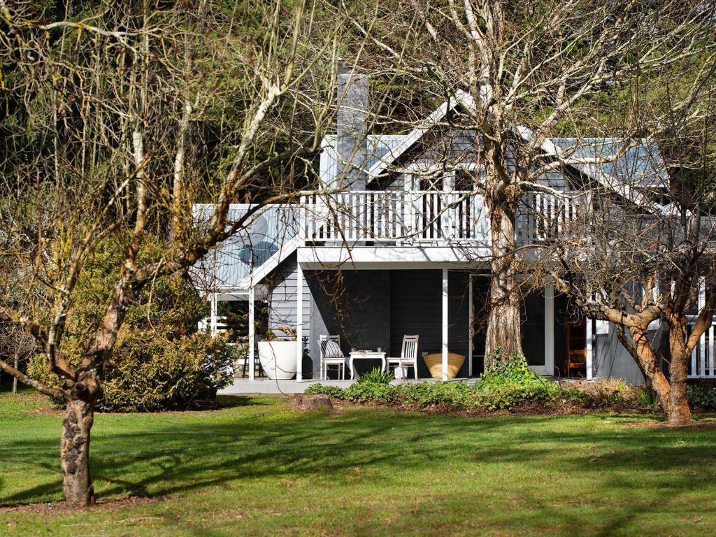 a house with a deck and a yard with trees at The Orchard in Daylesford