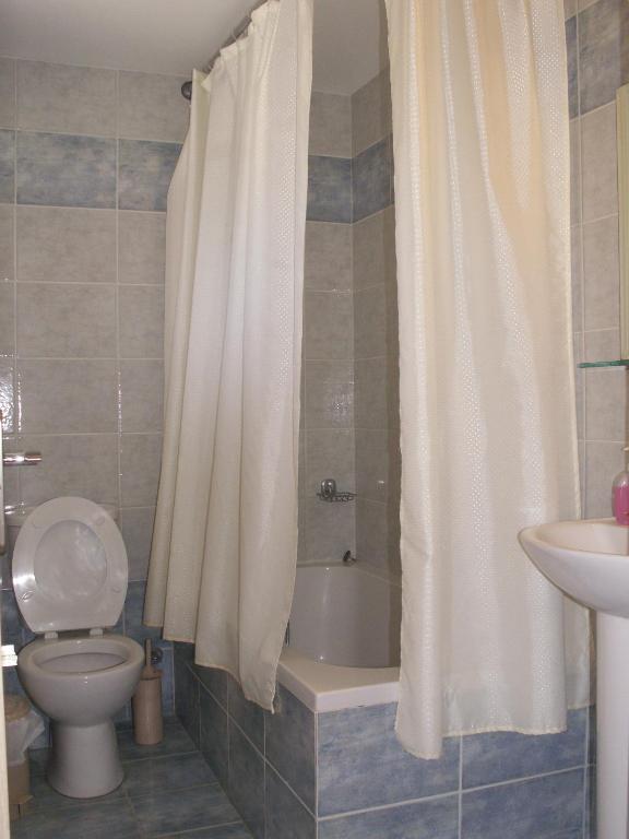 W łazience znajduje się toaleta, wanna i umywalka. w obiekcie Kastro Beach Hotel w mieście Kyllini