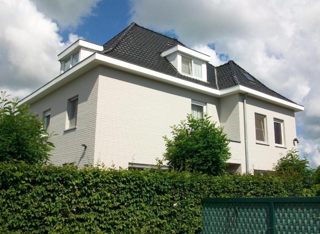 a white house with a black roof at B&B Bru-Beauline in Bruges