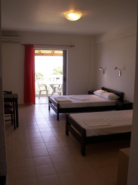 Pokój z 2 łóżkami, stołem i krzesłami w obiekcie Kastro Beach Hotel w mieście Kyllini
