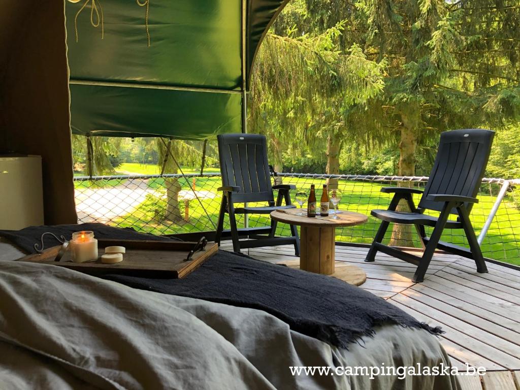 2 sedie e un tavolo su una terrazza di Camping Ardennes Insolites a Marbehan