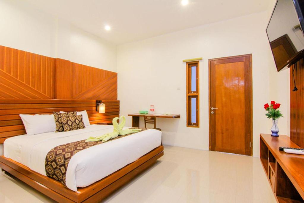 um quarto com uma cama grande e uma televisão em S5 Guest House Yogyakarta em Yogyakarta