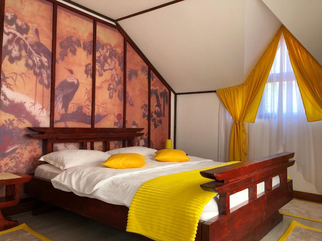 a bedroom with a large bed with yellow pillows at Casa Lily - Japanese Retreat in Sighişoara
