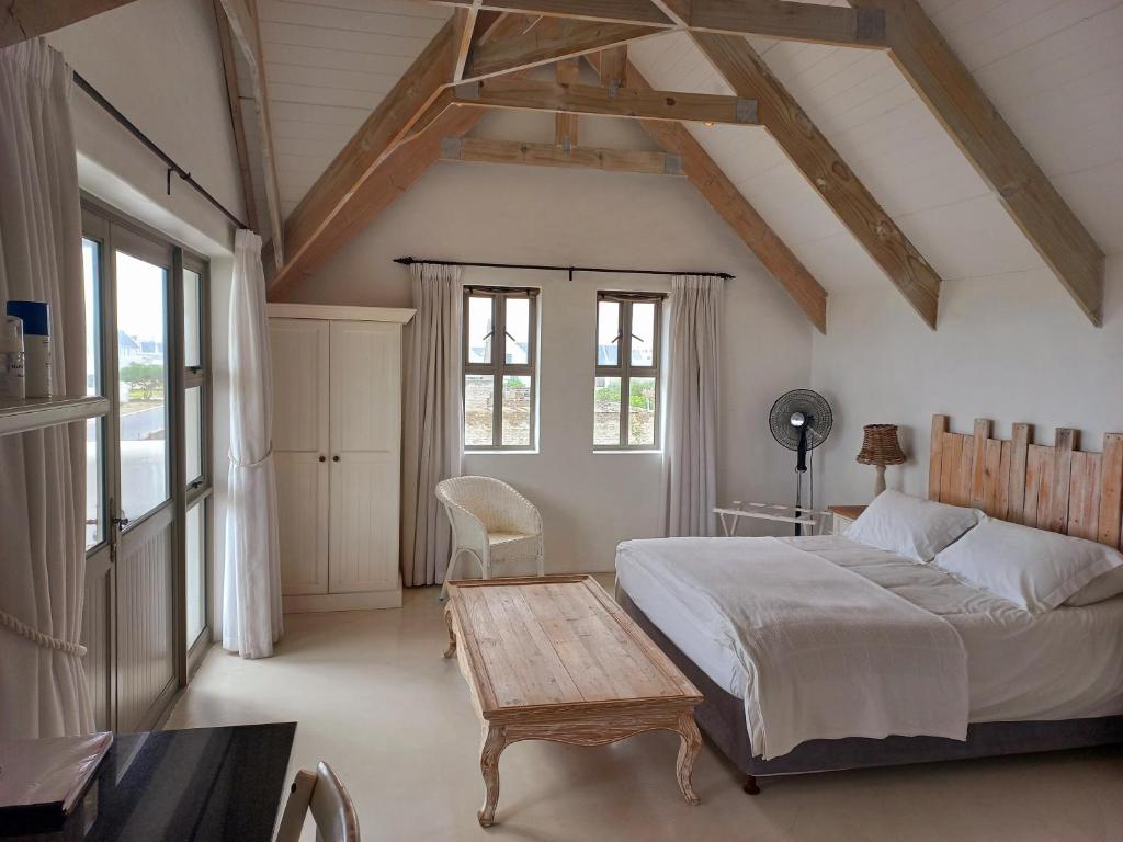 a bedroom with a bed and a wooden table at Serenity in Velddrif