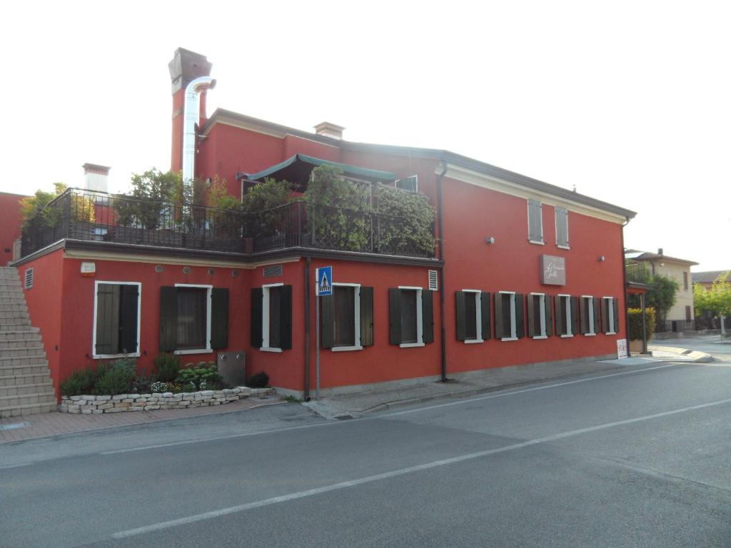 a red building on the side of a street at Locanda Gallo in Dolo