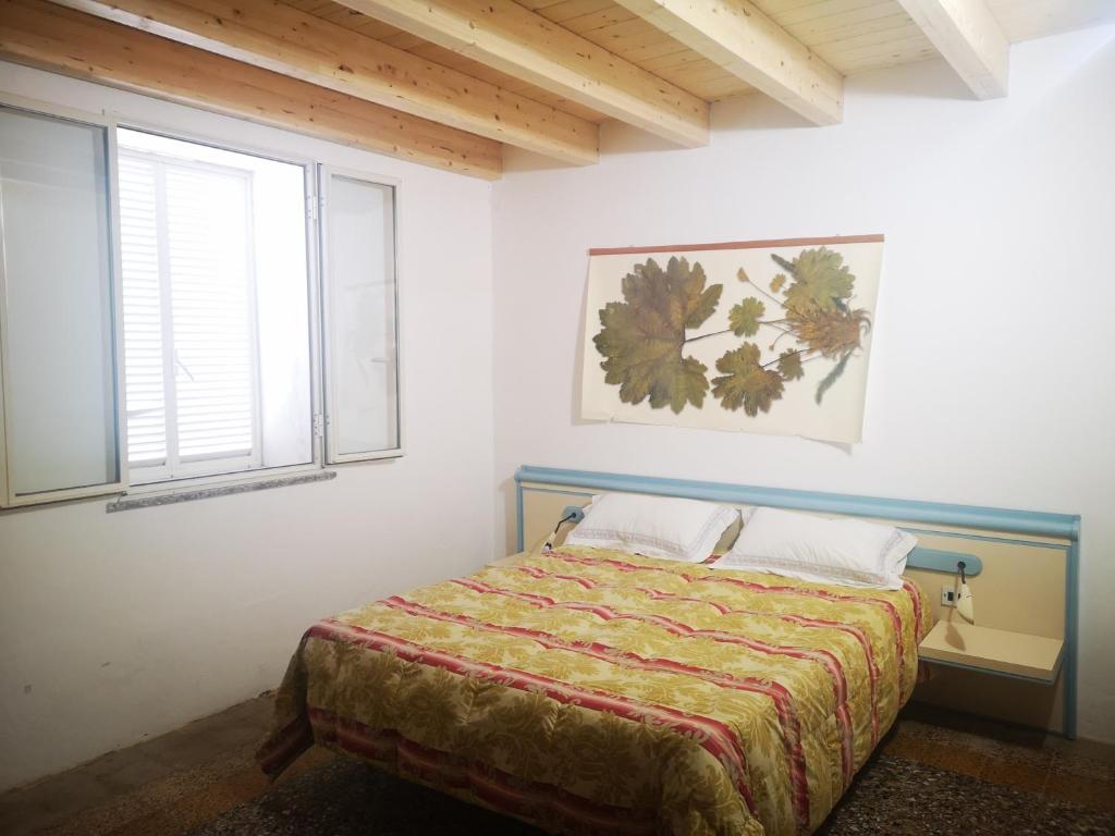 a bedroom with a bed and a window at Su Cuile historical country house with barbecue in Martis