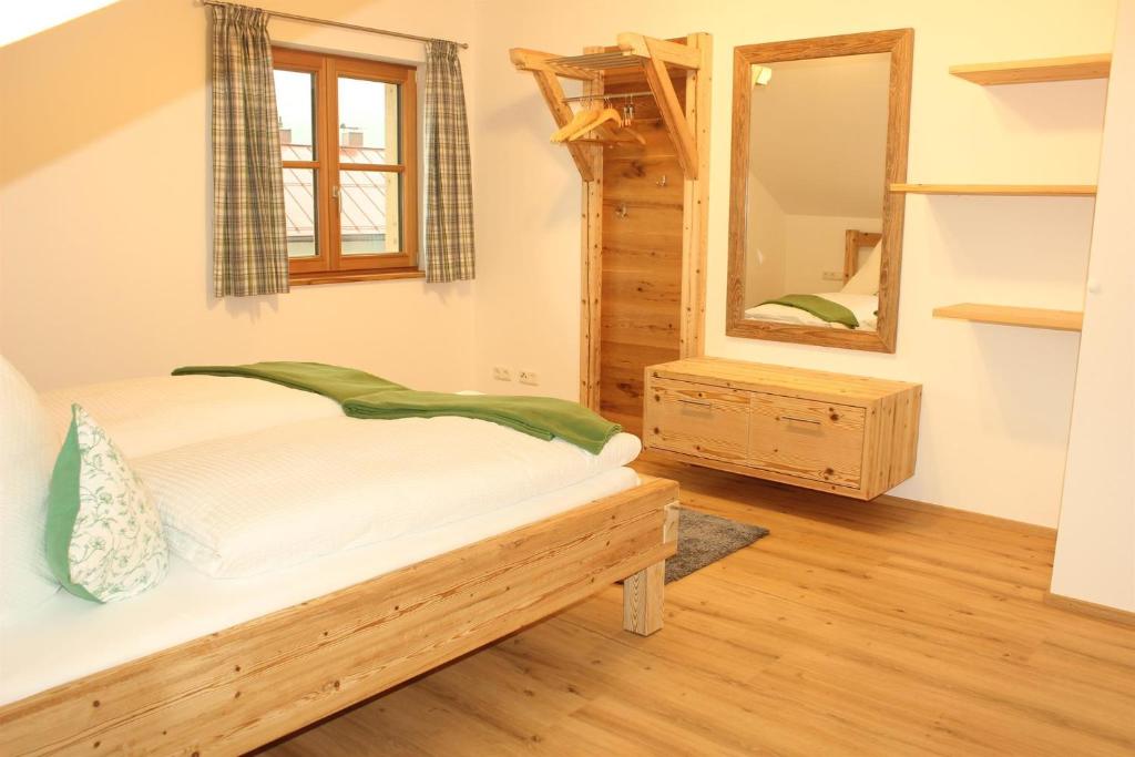 a bedroom with a bed and a mirror at Ferienwohnung Hutter in Fischen