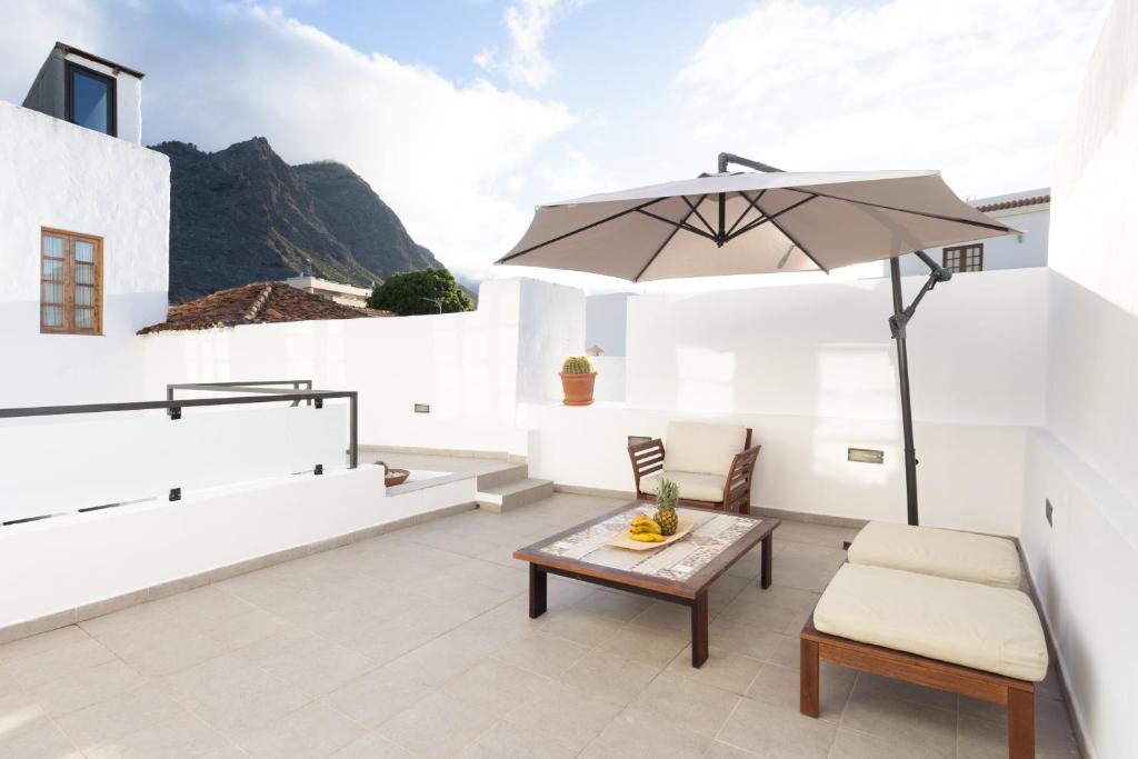 un patio con sombrilla, mesa y sillas en Home2Book Spectacular Studio Los Silos, Terrace, en Los Silos